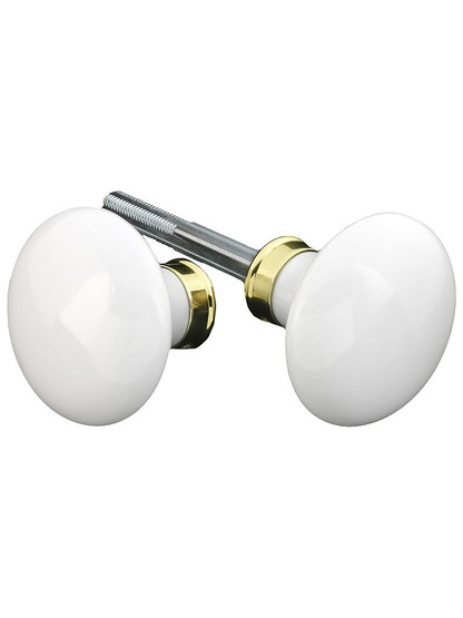 Pair of White Porcelain Door Knobs With Solid Brass Shank in Unlacquered Brass.